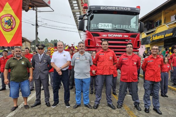 Bombeiros voluntários perfilados na frente da plataforma elevatória dos Bombeiros Voluntários de Joinville.